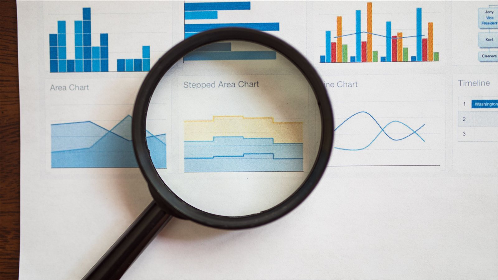 Lupa sobre gráficos e relatórios de dados, representando análise e estrutura de SEO