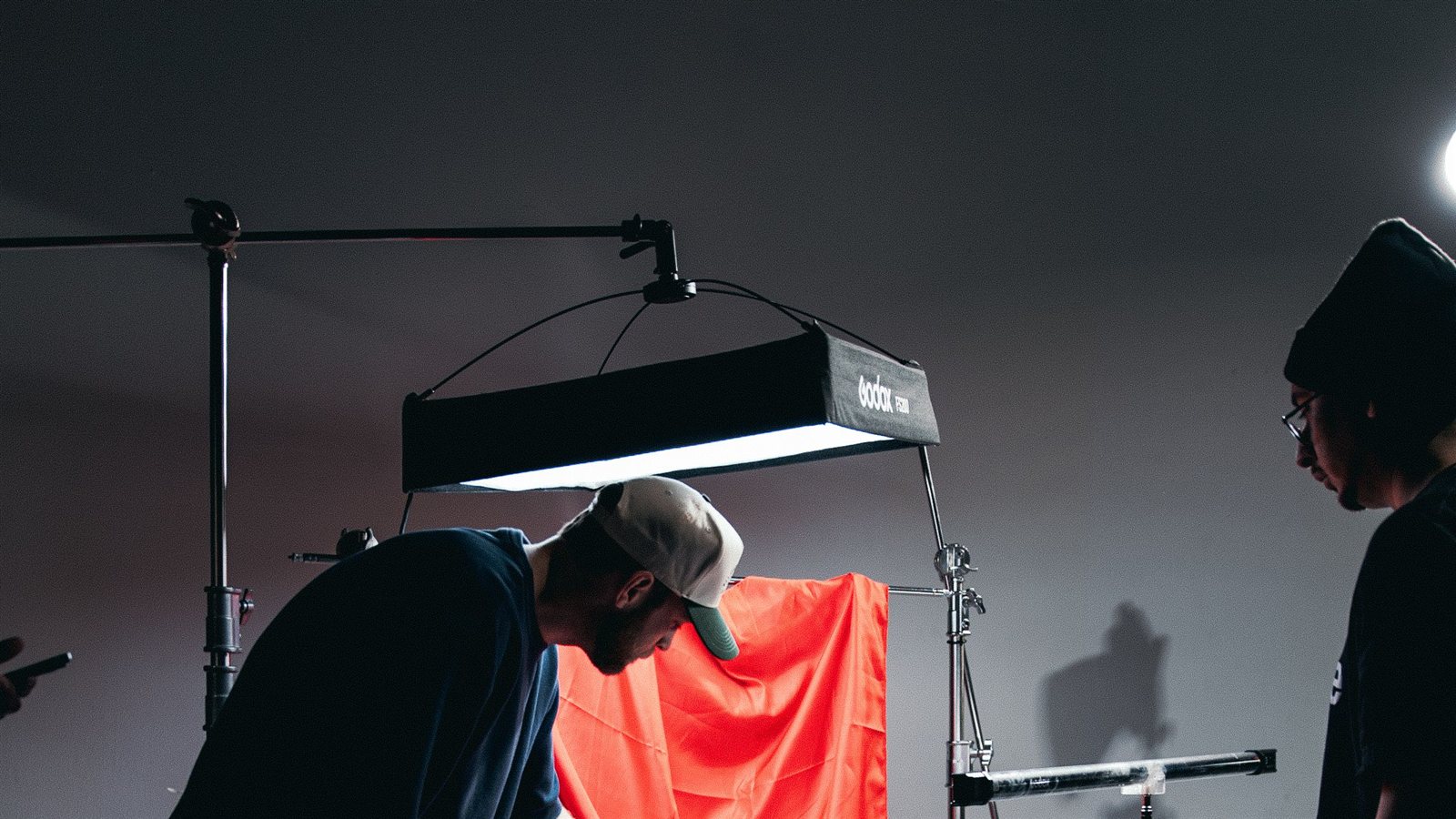 Bastidores de um set de filmagem profissional, com câmera, monitor de vídeo e iluminação de estúdio